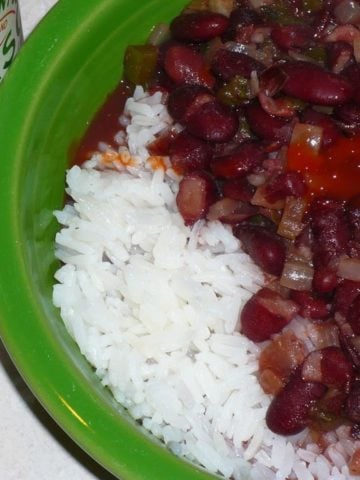A bowl of red beans and rice with tabasco