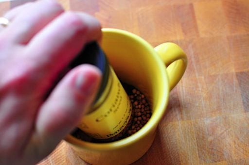 Grinding spices in a cup with a spice jar