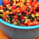 A blue bowl of multicolored cooked and chopped Swiss Chard | Swiss Chard Sauteed With Pine Nuts and Raisins