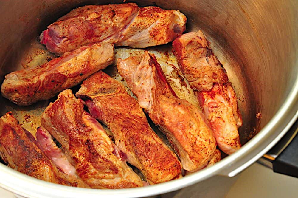 Browning the pork in the pressure cooker pot