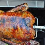 Cooked duck on a rotisserie spit