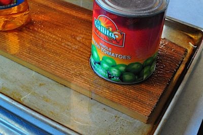 Cedar plank covered with water, held down with a large can