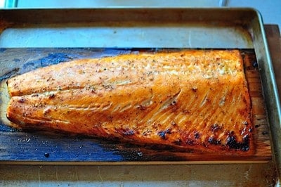Cedar plank salmon cooked and in a roasting pan