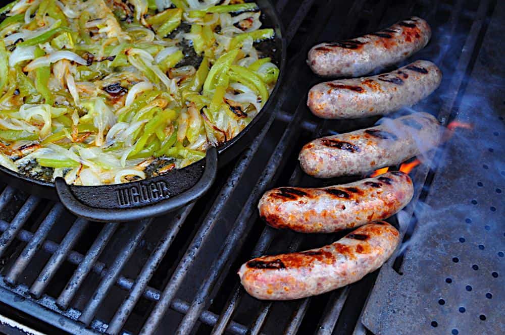 Browning the brats on the grill while the peppers and onions cook uncovered