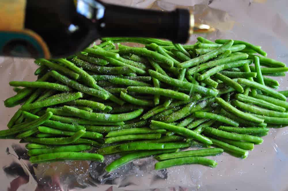 Olive oil drizzled onto a pile of green beans