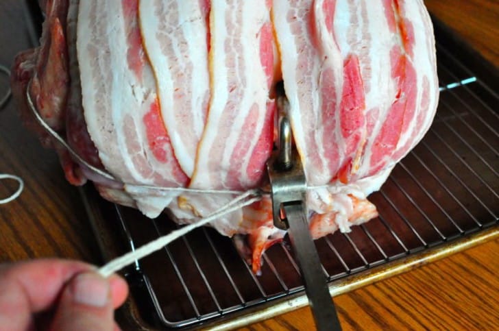 Trussing the bacon at the neck of the bird - get it tight!