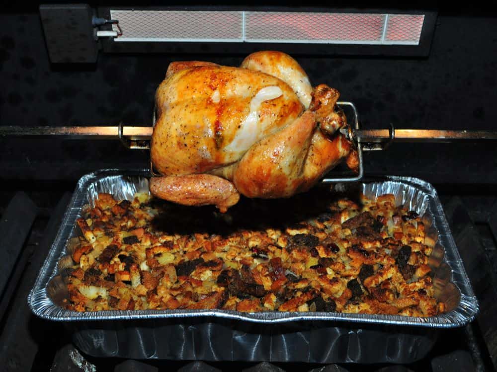 A rotisserie chicken over a pan of stuffing