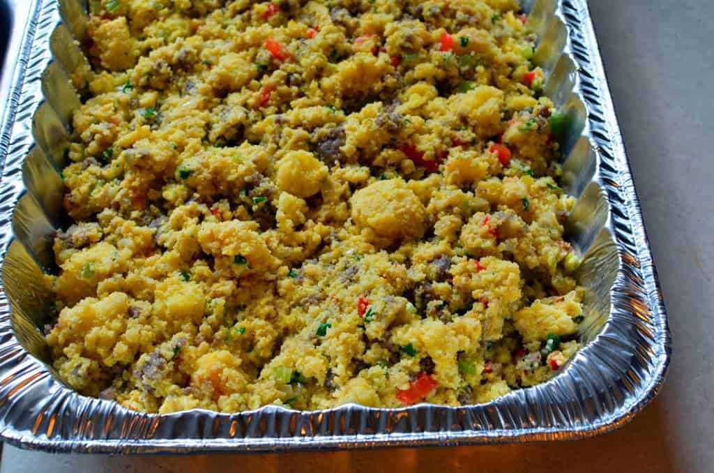 An aluminum foil pan full of cornbread dressing, ready for the oven or grill