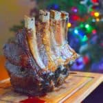Rib Roast on a cutting board in front of a Christmas tree