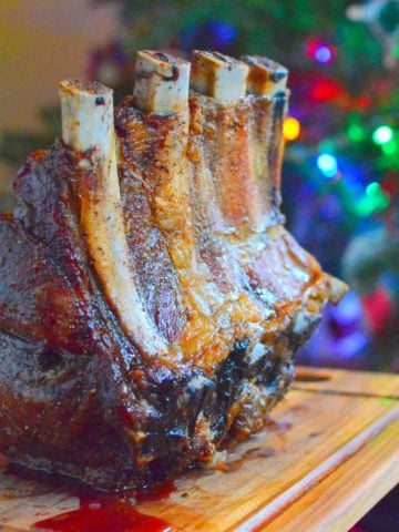 Rib Roast on a cutting board in front of a Christmas tree