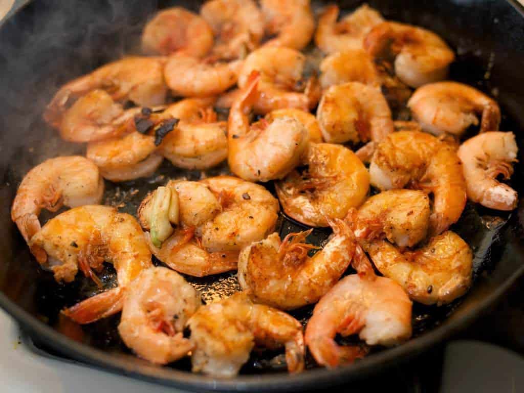 A frypan full of sautéed shrimp in garlic butter