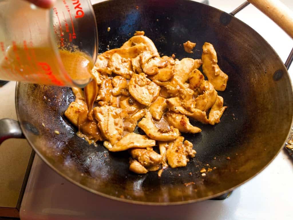 Pouring the sauce over the stir-fried chicken