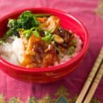 A bowl of velveted chicken stir fry on rice, with chopsticks