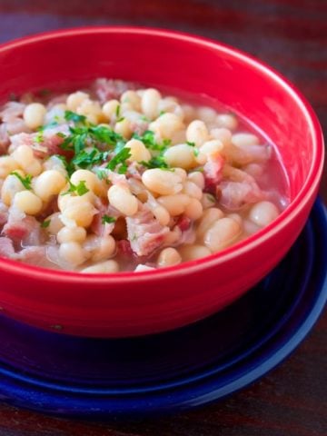 A red bowl of US Senate Bean Soup on a blue plate