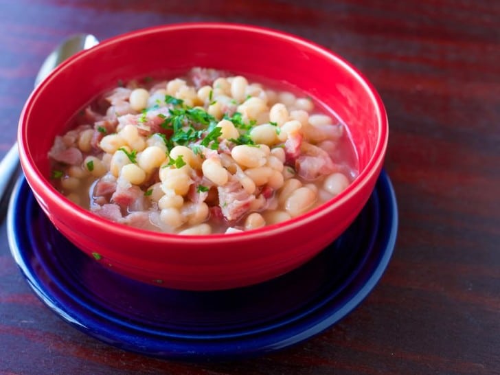 A red bowl of US Senate Bean Soup on a blue plate