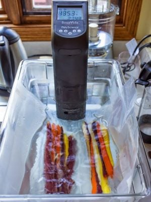 Vacuum sealed carrots in a water bath with a sous vide immersion circulator