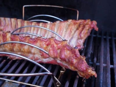 Baby back ribs in a rib rack on a gas grill