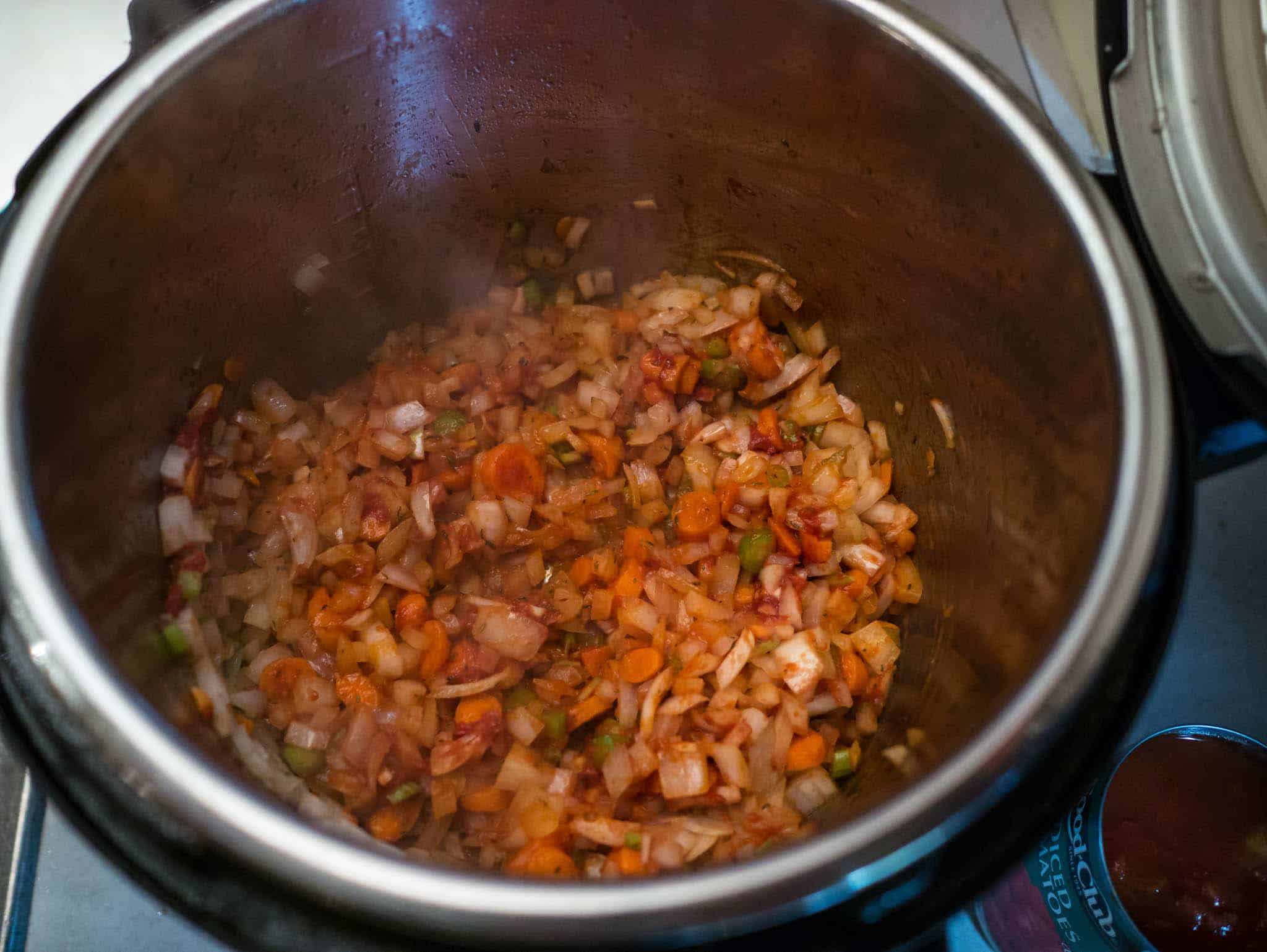 Sautéing the onion, carrot, celery, and tomato paste