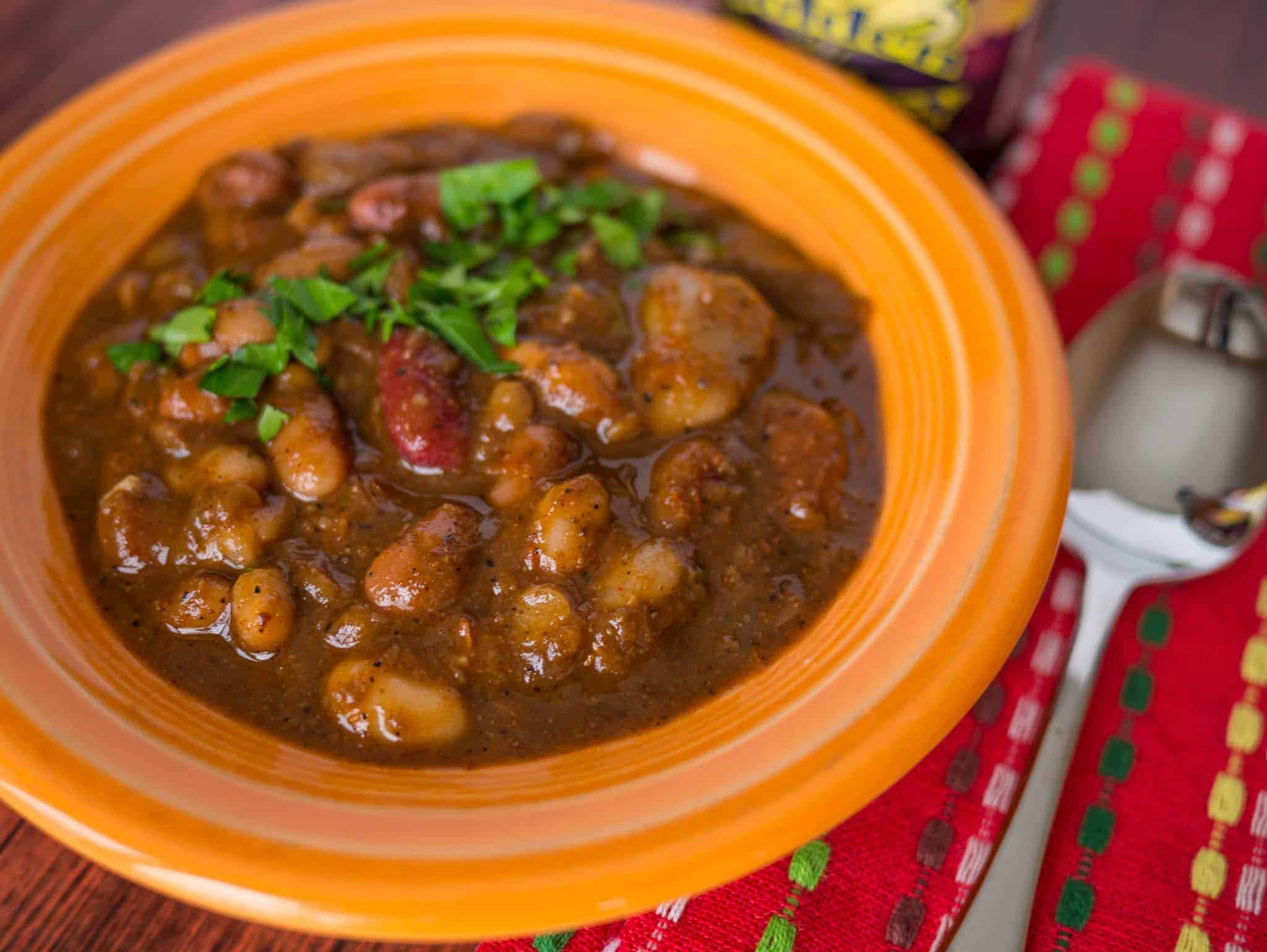 A bowl of 15 bean chili, with a red napkin and spoon