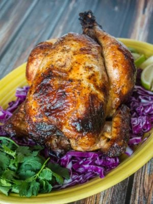 A Rotisserie Chicken (Pollo Asado)on a platter of shredded cabbage