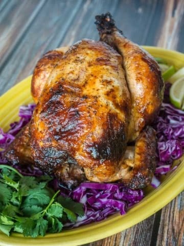 A Rotisserie Chicken (Pollo Asado)on a platter of shredded cabbage