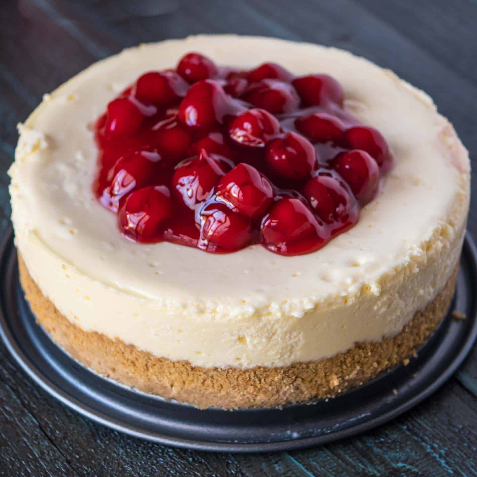 An Instant Pot New York cheesecake topped with cherries