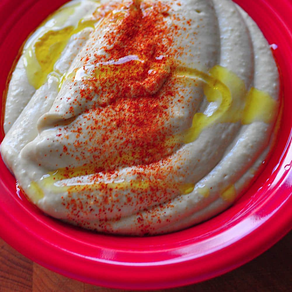 A bowl of Instant Pot Hummus drizzled with olive oil and sprinkled with paprika
