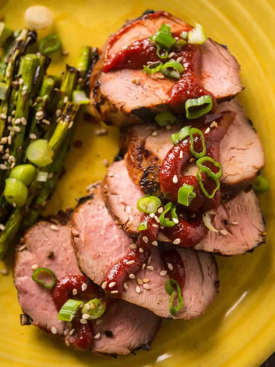 Slices of grilled pork tenderloin with gochujang and green onions