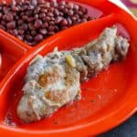 A plate with a country style rib and some beans