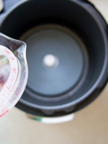 Water poised over an Instant Pot cooker base without the liner