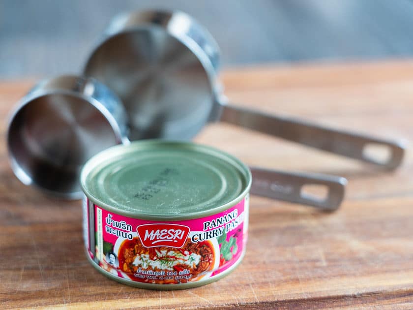 Can of Panang curry paste in front of two measuring cups