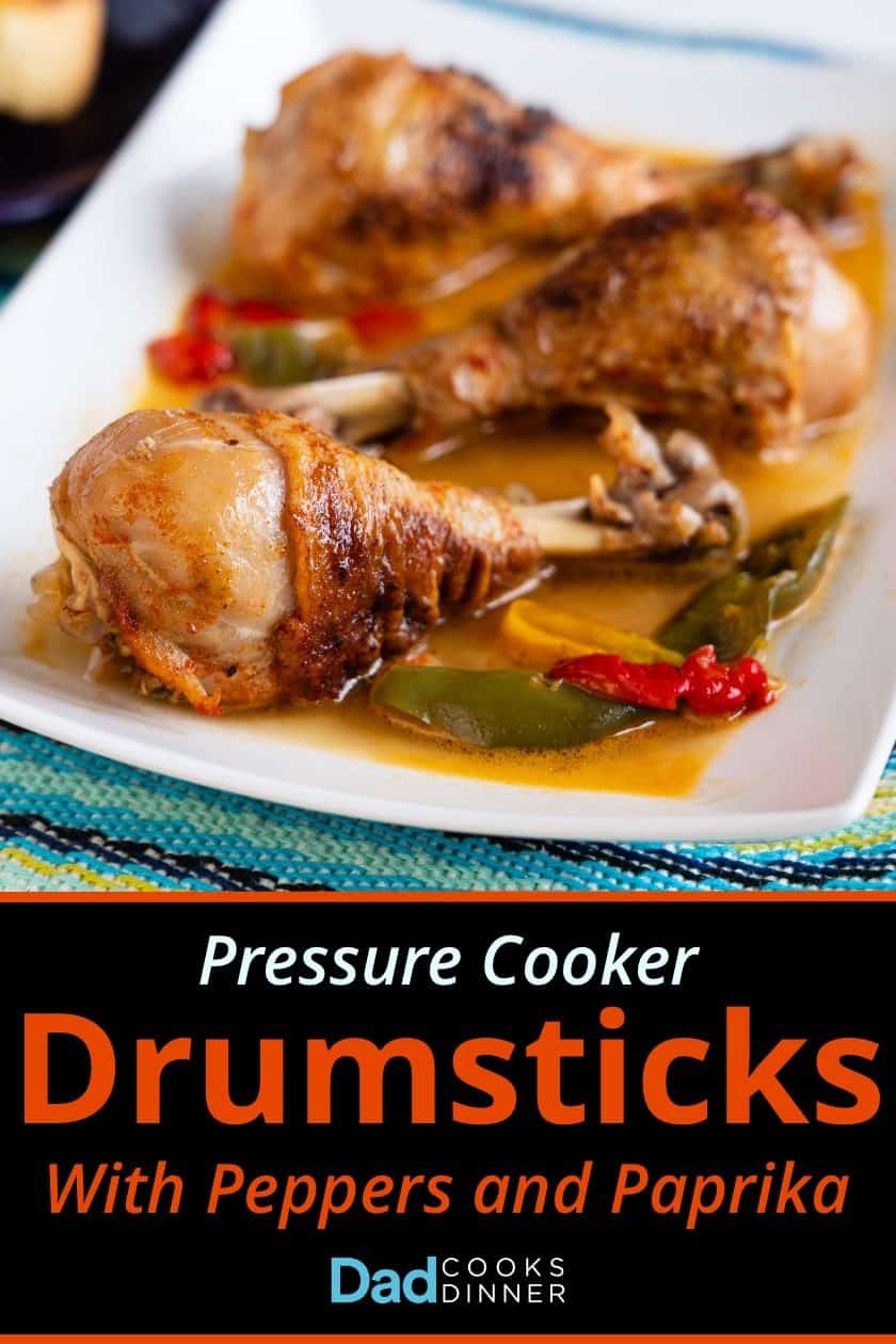 Chicken drumsticks with peppers and paprika on a white platter with recipe name in text below