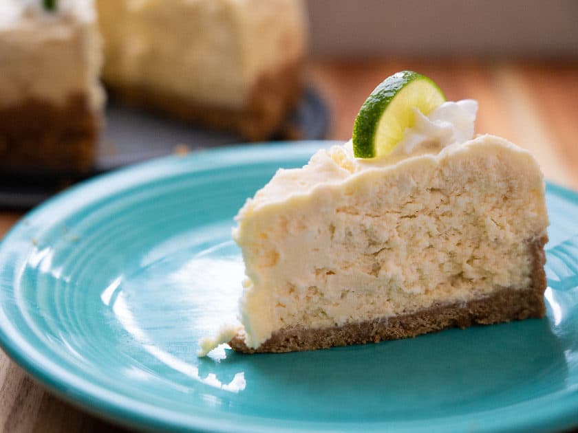 A slice of Pressure Cooker Key Lime Cheesecake on an aqua plate