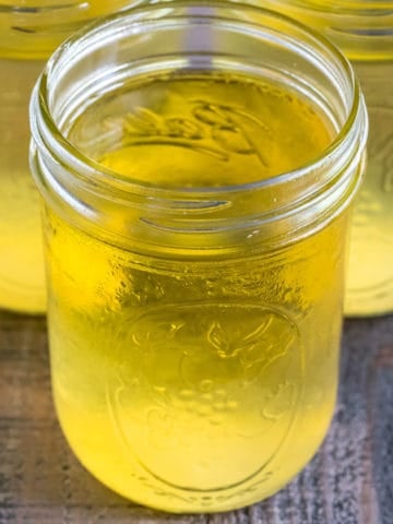 Close up of jars of vegetable broth on a wood table