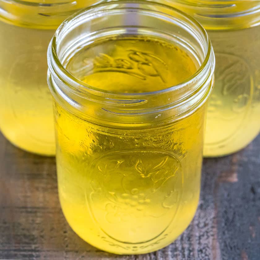 Close up of jars of vegetable broth on a wood table