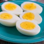 Hard-boiled egg halves on a teal plate