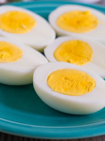 Hard-boiled egg halves on a teal plate