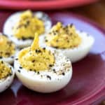 Wasabi deviled eggs on a purple plate