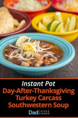 An aqua colored bowl full southwestern turkey soup, topped with shredded cabbage and cheese, with bowls of tortillas, limes, and shredded cabbage in the background, with the text Instant Pot Day-After-Thanksgiving Turkey Carcass Soup | DadCooksDinner underneath