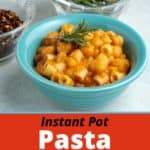 A teal bowl of pasta and chickpeas, with a sprig of rosemary on top, and a bowl of rosemary sprigs and red pepper flakes in the background.