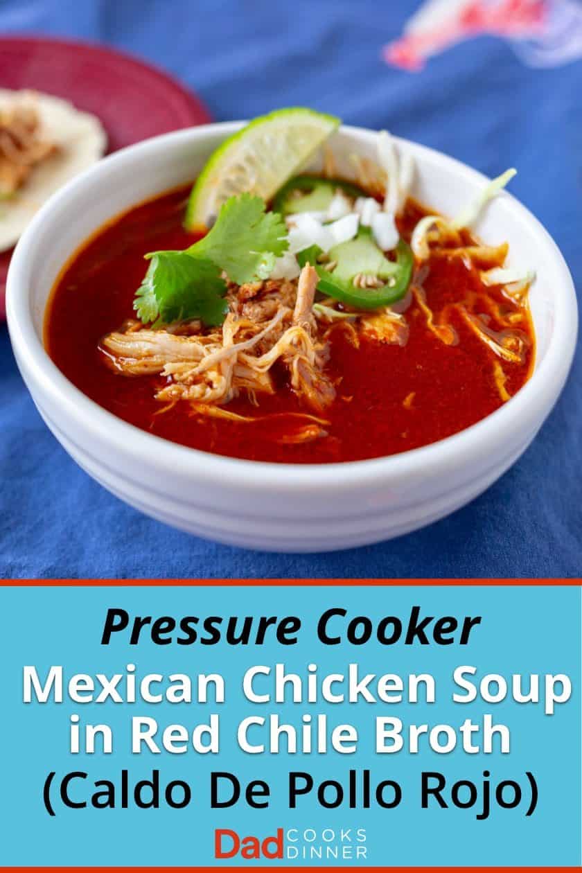 Bowl of Mexican Chicken Soup in Red Chile broth, with shreds of chicken, cilantro leaves, jalapeno slices, and diced onion on top