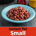 A bowl of red beans in front of a pressure cooker, a salt pig, and a pepper grinder