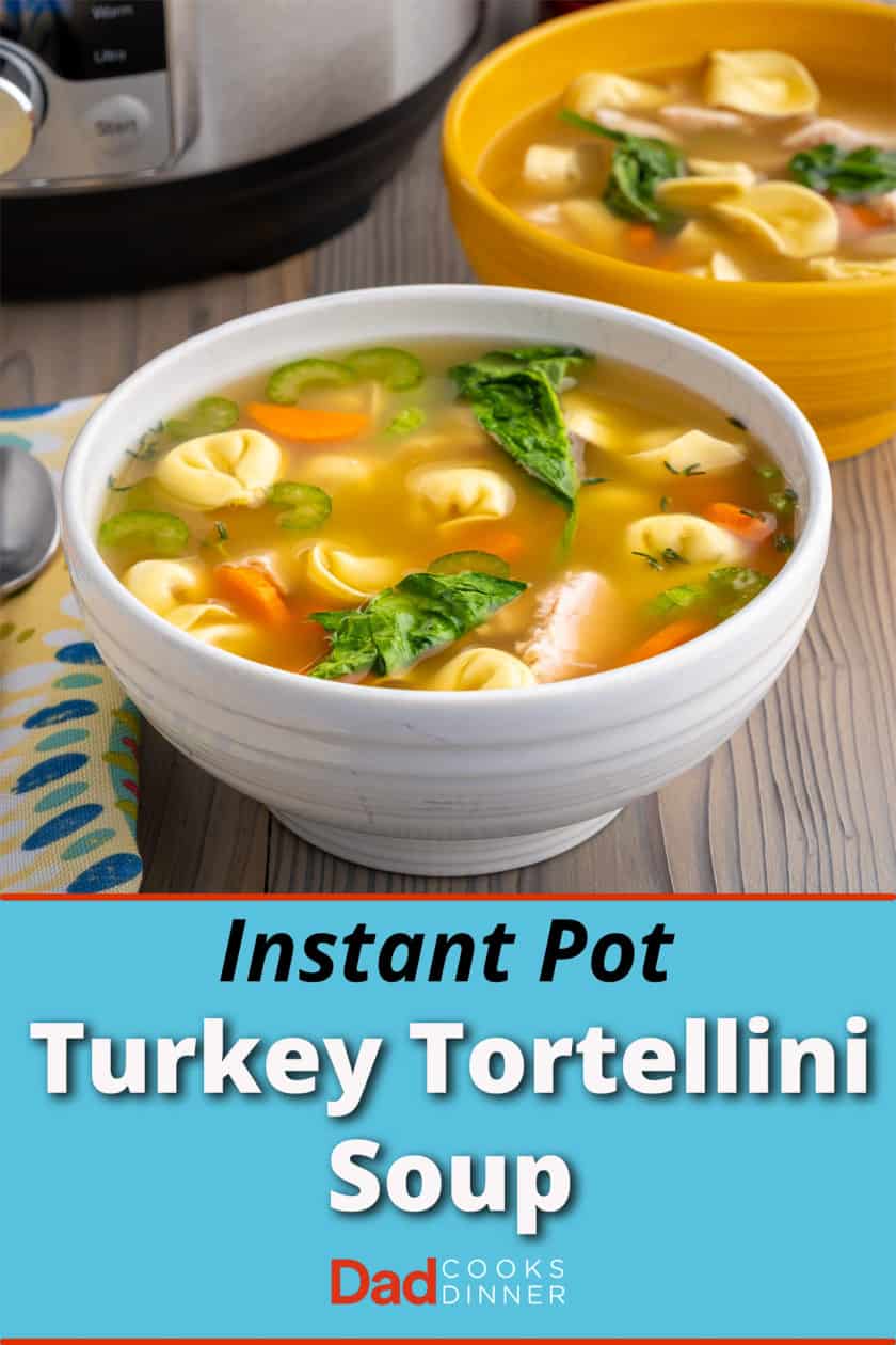 A bowl of turkey tortellini soup with carrots, spinach, tomatoes, and celery, with an instant pot visible in the background