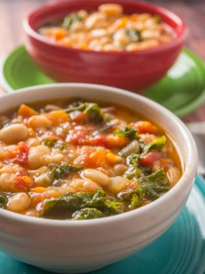 Two bowls of Tuscan bean soup on colorful plates