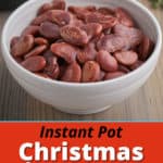 A white bowl of Christmas lima beans on a wood table with an Instant Pot and sprig of thyme in the background.