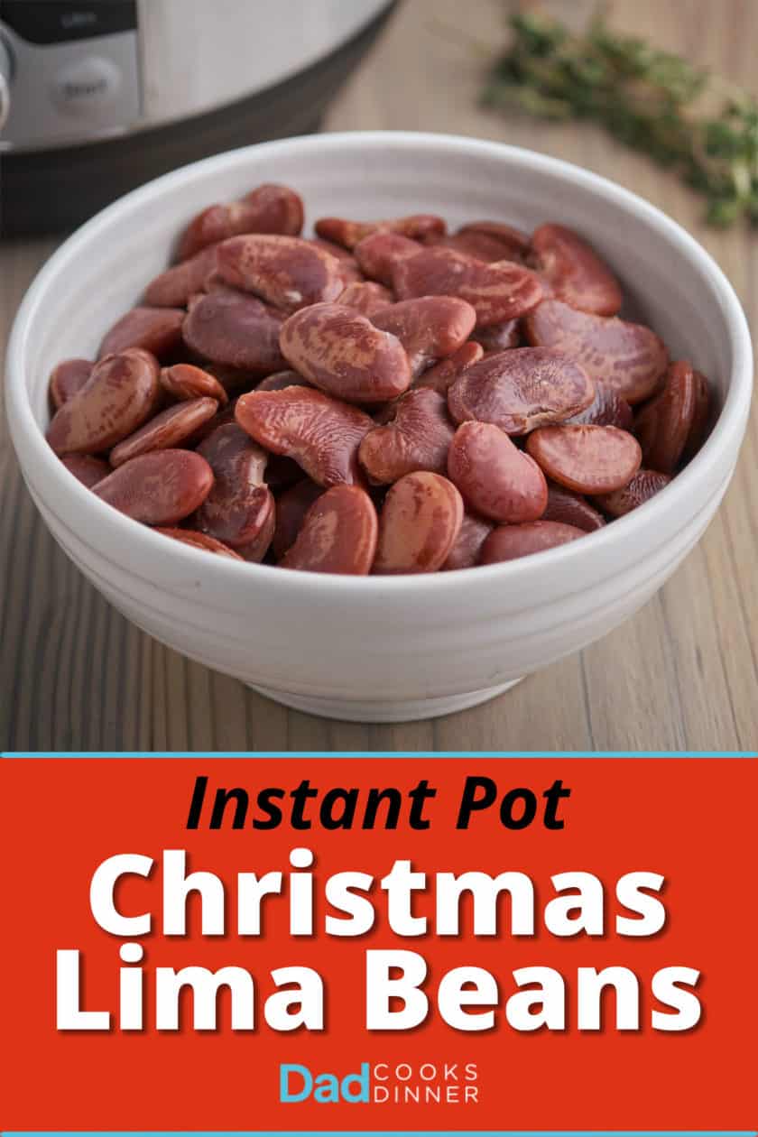 A white bowl of Christmas lima beans on a wood table with an Instant Pot and sprig of thyme in the background.