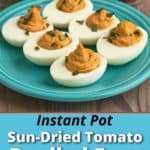 Sun-dried tomato deviled eggs on a plate, sprinkled with basil, with basil leaves and sun-dried tomatoes in the background.