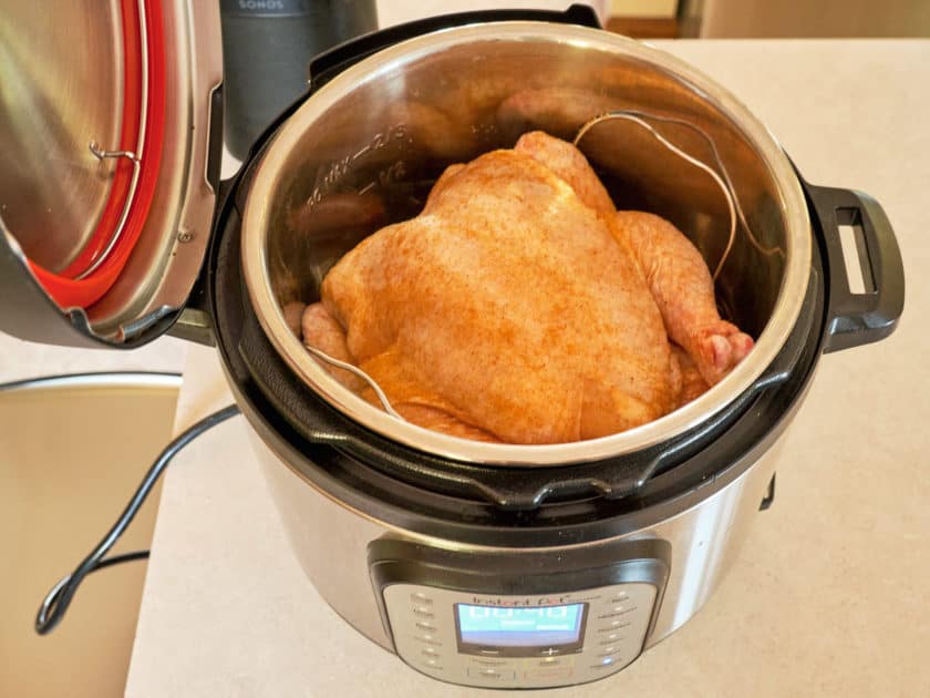 A whole chicken sprinkled with Cajun Spice Rub in an Instant Pot, ready to cook