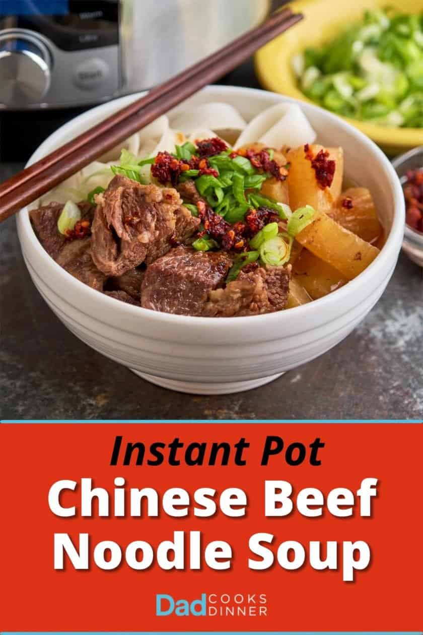 A bowl of Chinese beef noodle soup, with green onions and chili crisp