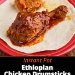 An Ethiopian chicken drumstick, coated with sauce, on a tortilla on a red plate